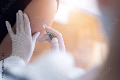 Close up of a Doctor making a vaccination in the shoulder of patient, Flu Vaccination Injection on Arm, coronavirus, covid-19 vaccine disease preparing for human clinical trials vaccination shot.