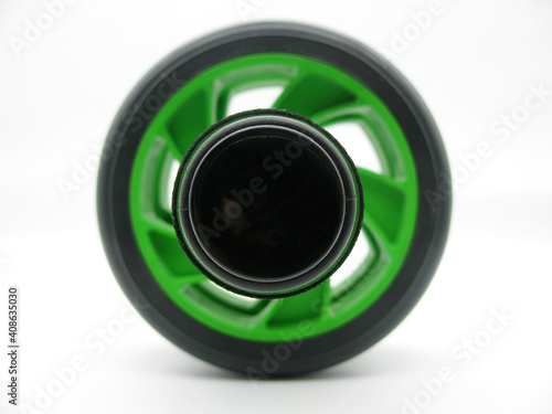 Black and green fitness and roller wheel or pumping abs and other muscles on white background. Side view.