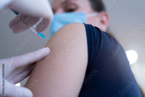 Close up of a Doctor making a vaccination in the shoulder of patient, Flu Vaccination Injection on Arm, coronavirus, covid-19 vaccine disease preparing for human clinical trials vaccination shot.