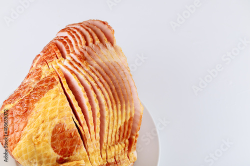 Whole spiral sliced hickory smoked pork ham on white background.