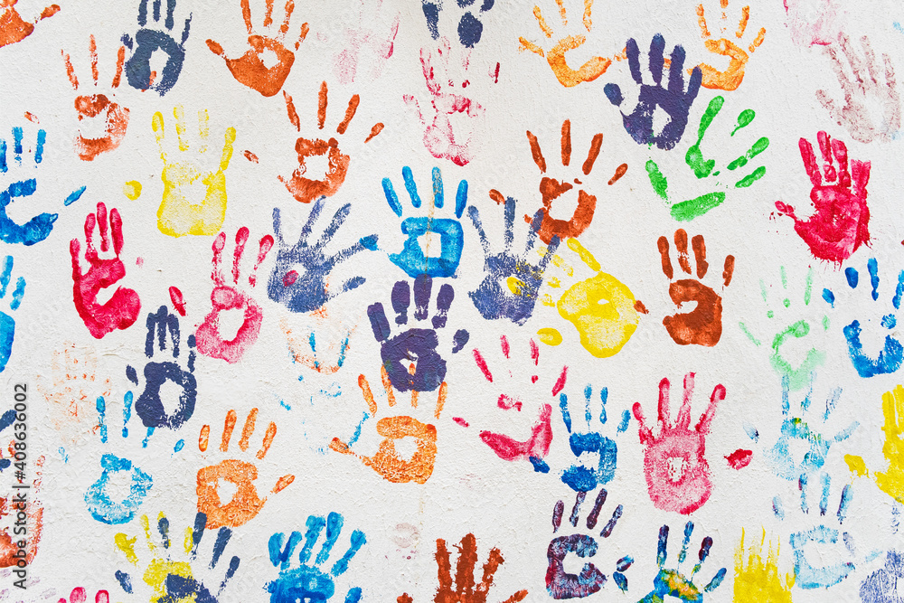 White wall with colorful multicolored hand prints.