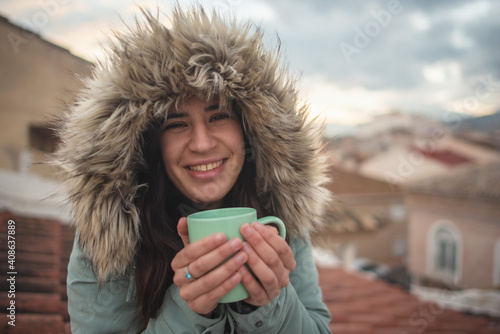 Woman in a moment of relaxation drinking tea on the roof her house