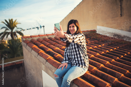 Fotografija Creative girl works the roof of her house