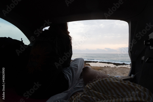 girl looking at the sea from a camper car