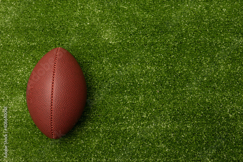 American football ball isolated on top of green grass. American football ball with green grass copy space