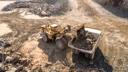 A Digger and Dump Truck Working in a Quarry For Mining