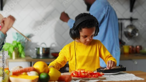 Cute Adorable Little Child Playing DJ Using Hardware Electronic Sound Mahcine Performing Song for Parents Dancing in the Kitchen Cooking Food. photo