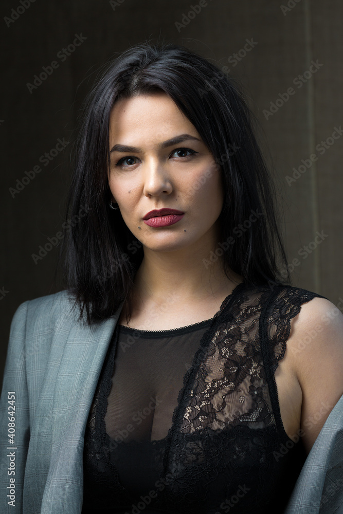 Portrait of a young sexy brunette girl in a lace top in dramatic tones. Vintage photo.
