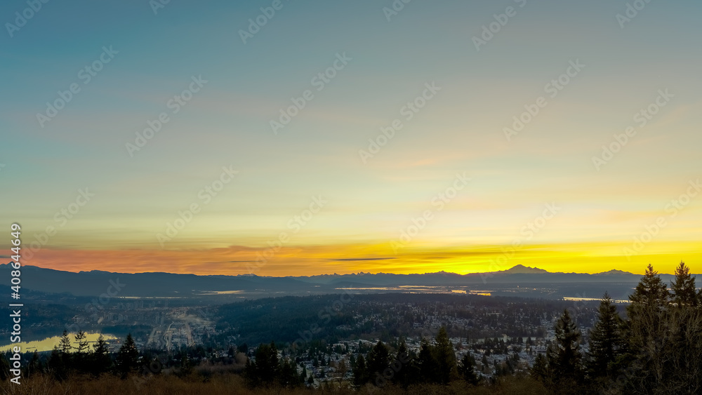 Sunrise over Fraser Valley, Port Moody, Burnaby and Burrard Inlet, BC with mountains on horizon

