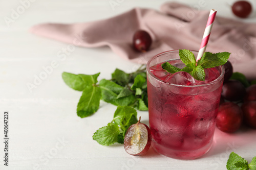 Delicious grape soda water with mint on white table. Refreshing drink