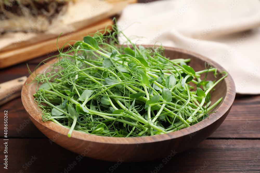Plate with fresh microgreen on brown wooden table, closeup Plate with fresh microgreen on brown wooden table, closeup