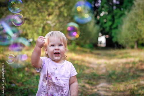 little girl looking at soap bubbles