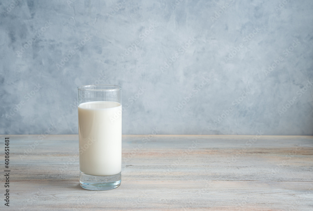 Milk in a long transparent glass on a gray-blue background. Side view with copy space. The concept of dairy products. Milk in a long transparent glass on a gray-blue background. Side view with copy space. The concept of dairy products.