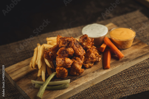 Photography boneless de pollo calientes y servidas en tabla alitas de pollo