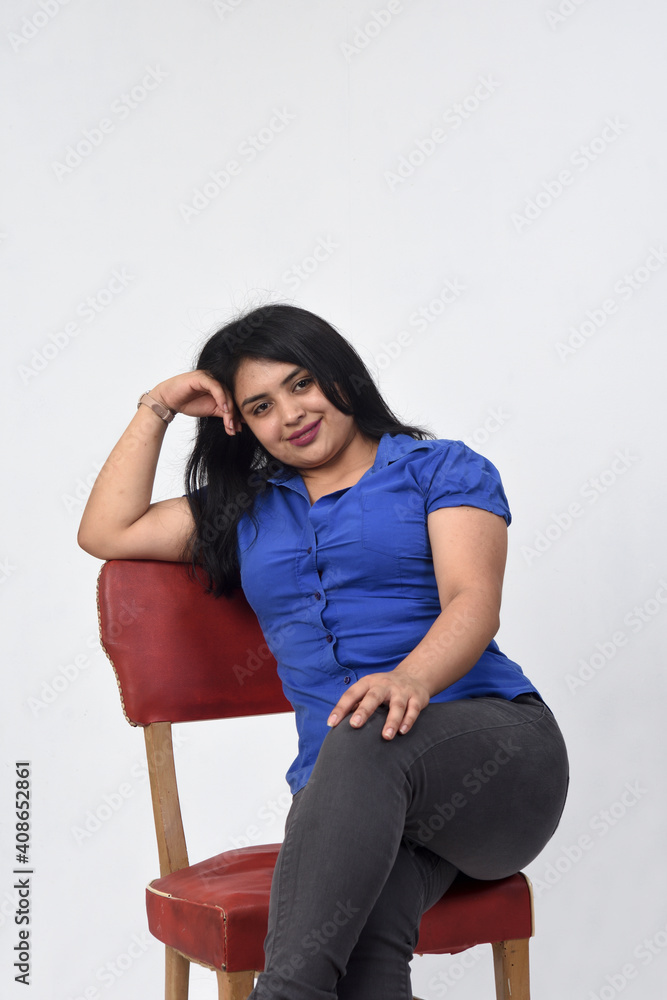 Fototapeta premium latin american woman sitting on a chair hand on head and looking at camera on white background