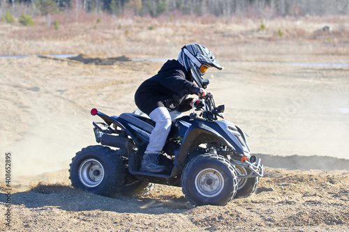 A young boy on his atv with a dusty background
