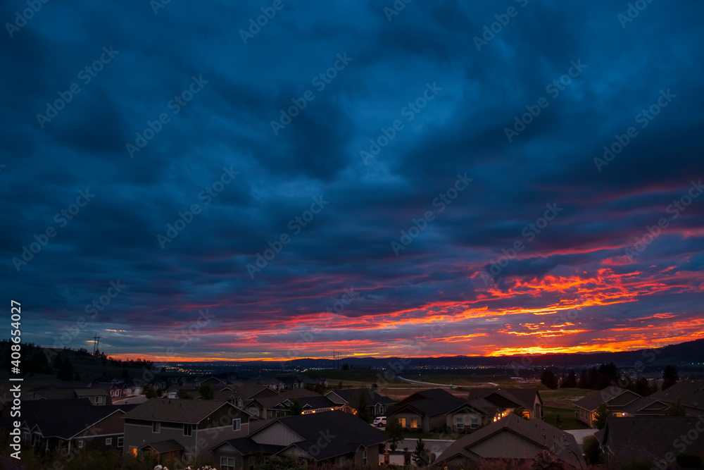 Naklejka premium Colorful storm clouds at sunset over the cities of Liberty Lake, Spokane and Spokane Valley in the Northern state of Washington, USA.