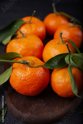 Freshly harvested tangerines from organic farming exposed on dark background.