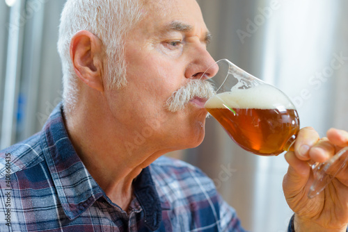 senior man drinking beer from a glass