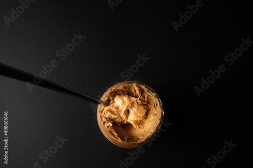 An open jar of peanut butter with a spoon