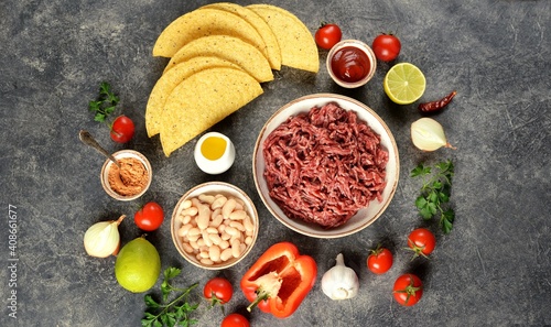 Ingredients for making tacos - ground beef, vegetables, spices, and corn shells. © chudo2307