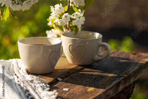 Cups with heart decor, lace napkin on a wooden table