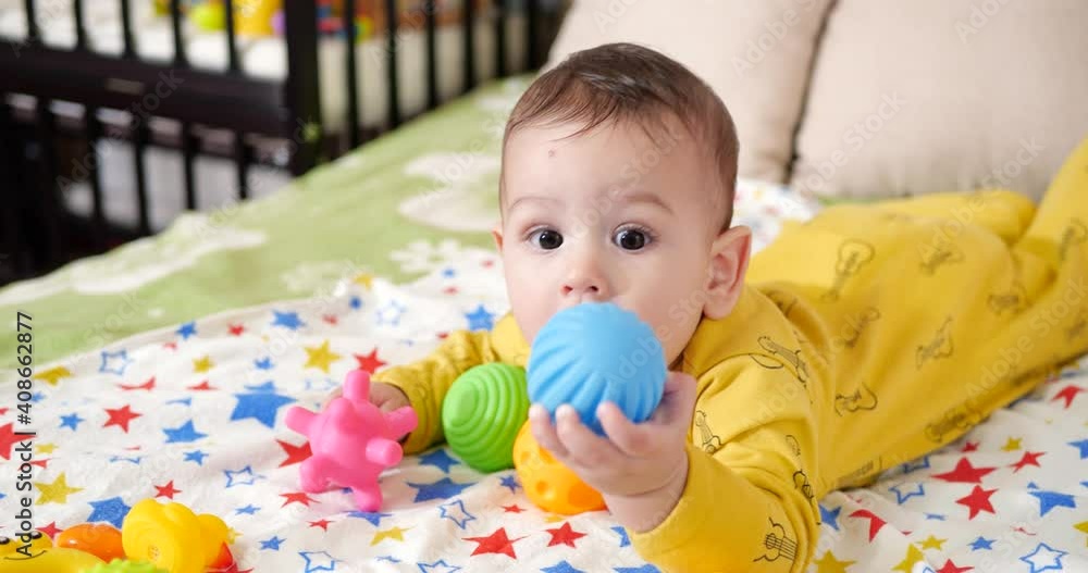 infant, childhood concept - close-up of smiling happy Baby plays with a teether. Teeth cutting. First teeth. Joy toothless 7 months baby bite, gnaws teether toy infant, childhood concept - close-up of smiling happy Baby plays with a teether. Teeth cutting. First teeth. Joy toothless 7 months baby bite, gnaws teether toy