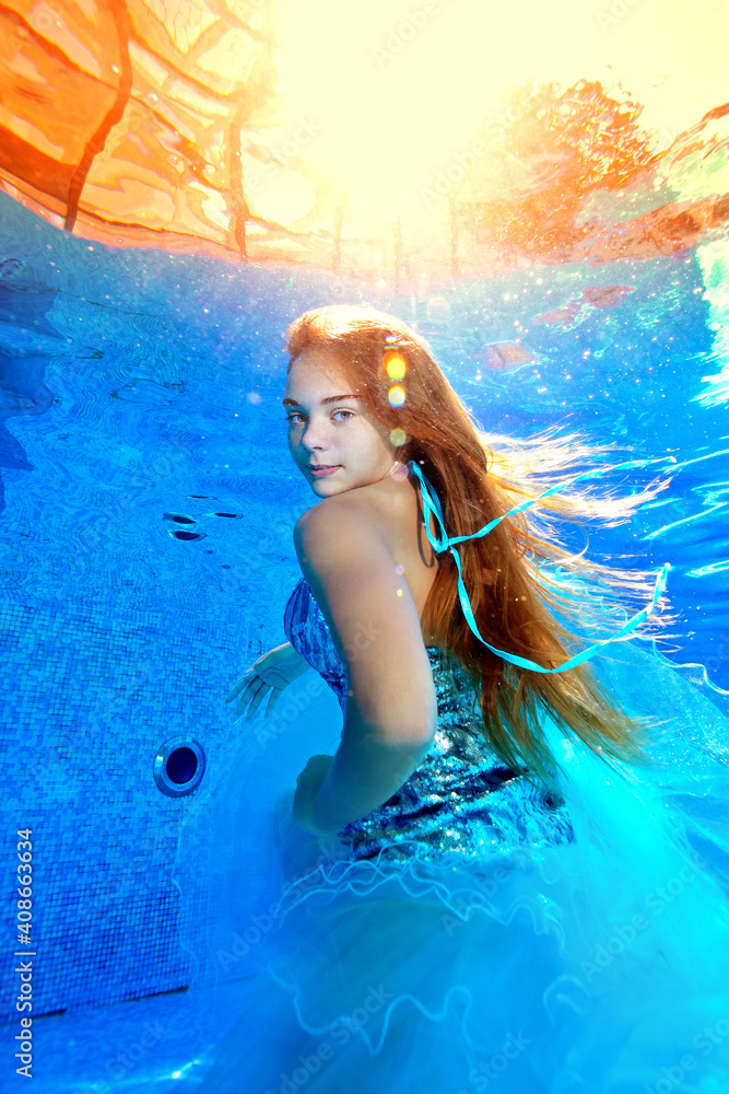 An unusual underwater portrait of a beautiful young girl who poses in a ...