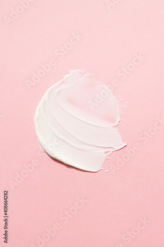 Cosmetic, smear, mask, cream. For care skin. A light cream smear on a pink background.