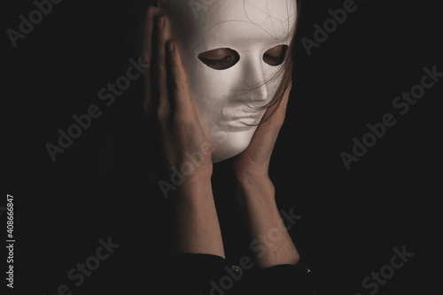 portrait of a woman in a white mask in the dark.