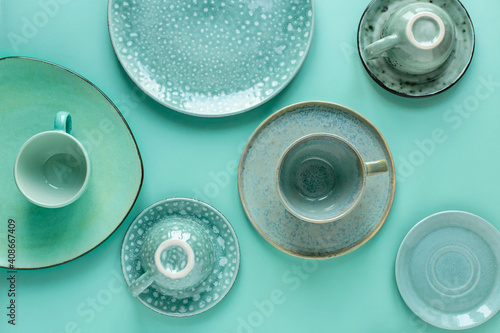 Handmade turquoise earthenware on a mint background. Top view, horizontal image.