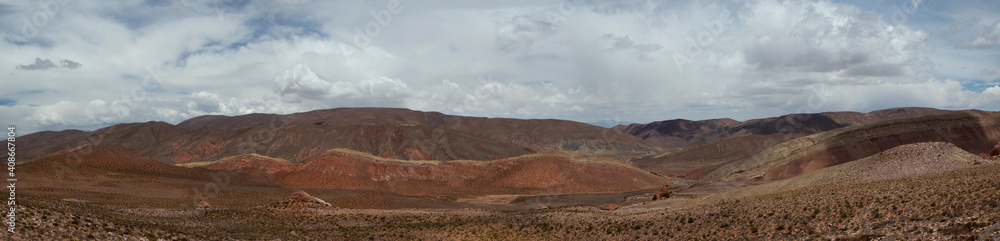 The arid desert. Altiplano. Panorama view of the dry land, valley and colorful mountains under a beautiful sky.