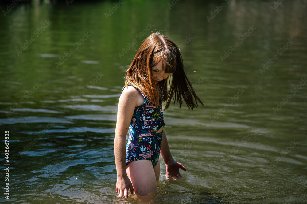 Portrait of a young happy girl playing in a river on a sunny day Portrait of a young happy girl playing in a river on a sunny day