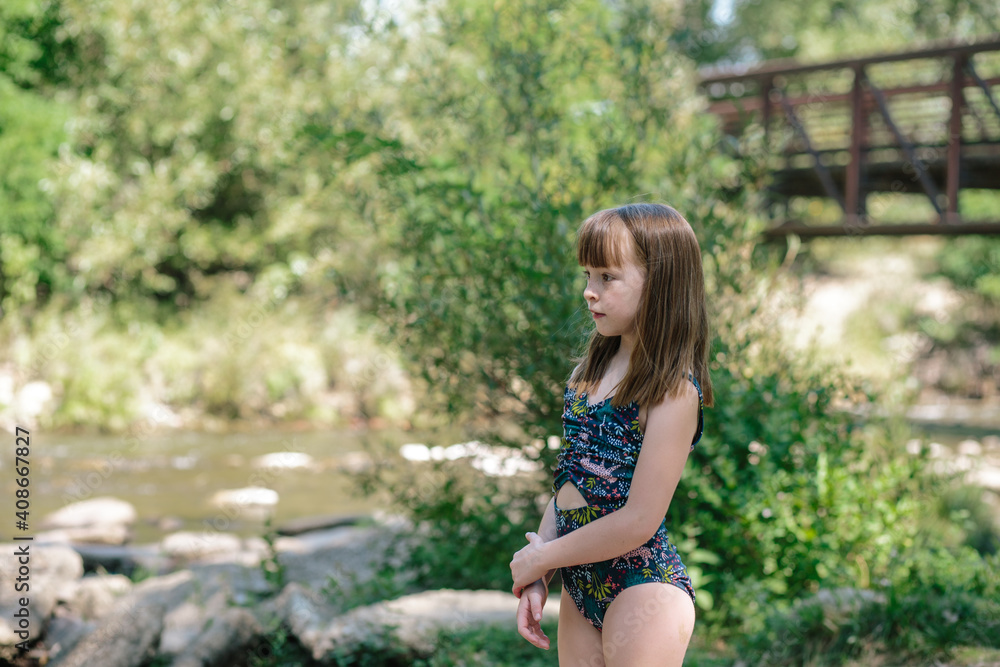 Young girl watching a small river on a summer day Young girl watching a small river on a summer day