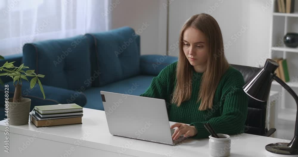 young woman is working with laptop in living room, surfing internet by modern notebook, using social nets young woman is working with laptop in living room, surfing internet by modern notebook, using social nets