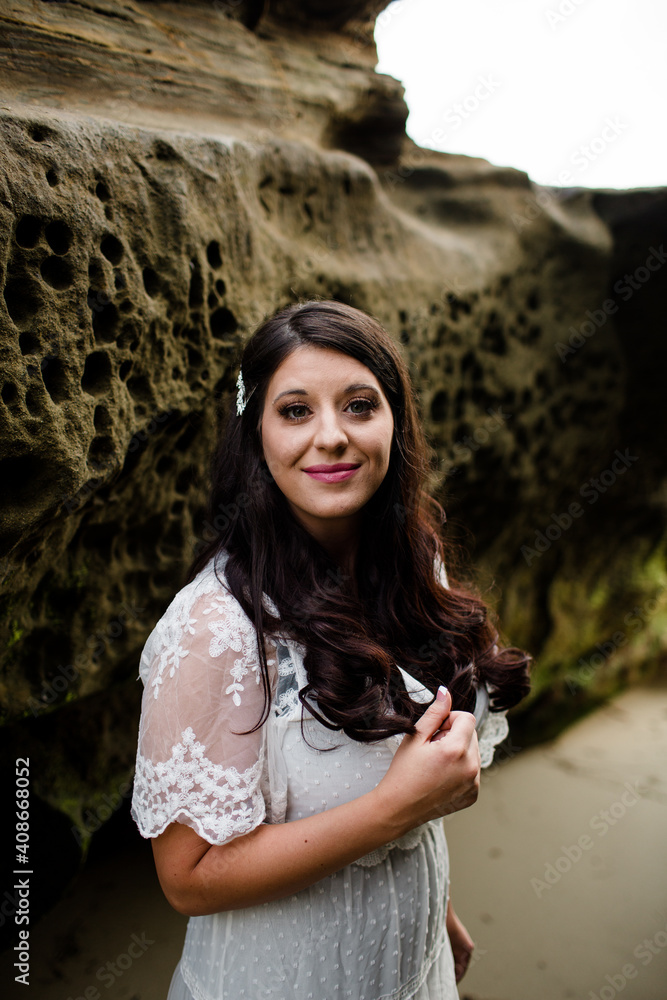 Newlywed Bride Standing Between Rocks on Beach in San Diego Newlywed Bride Standing Between Rocks on Beach in San Diego