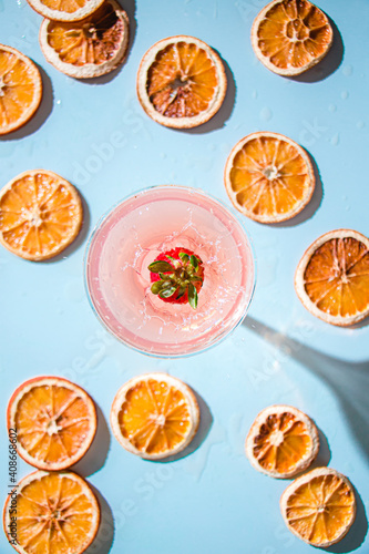 splashing strawberry into orange cocktail