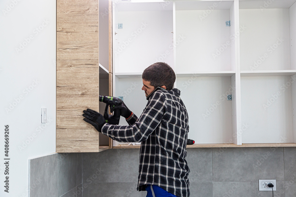 A carpenter works while talking on the phone A carpenter works while talking on the phone