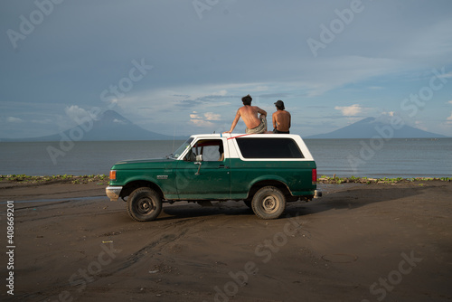 two friends looking at the volcanos from the roof of a truck 
