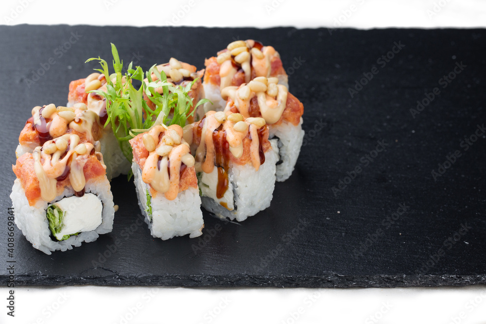 Traditional delicious fresh sushi roll on a black background with reflection. Sushi roll with rice, cream cheese, red fish, salmon. Sushi menu. Seafood, Asian cuisine.Baked sushi. Hot sushi Traditional delicious fresh sushi roll on a black background with reflection. Sushi roll with rice, cream cheese, red fish, salmon. Sushi menu. Seafood, Asian cuisine.Baked sushi. Hot sushi