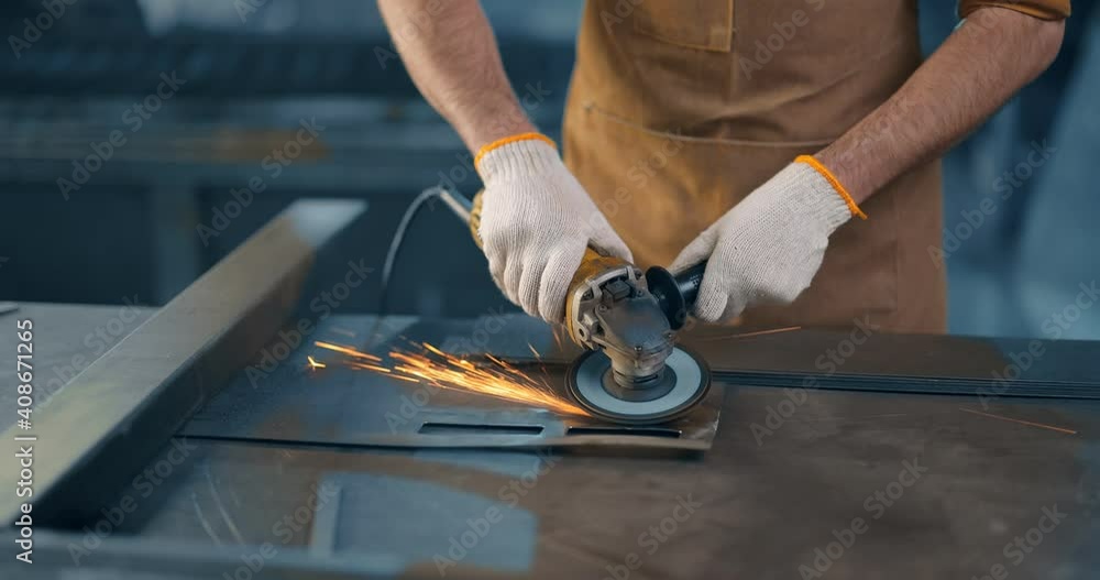 Metal industry worker grinding steel product at the factory, close-up shot. Grinding metal with sparks Metal industry worker grinding steel product at the factory, close-up shot. Grinding metal with sparks