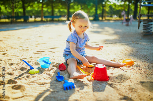 Fototapeta Adorable little girl having fun on playground in sandpit