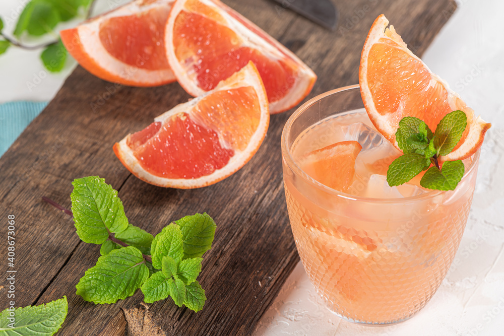 Grapefruit juice with mint in glasses on the table. Refreshing summer cocktail. Grapefruit juice with mint in glasses on the table. Refreshing summer cocktail.