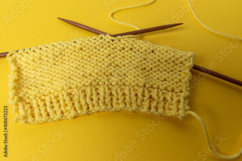 yellow wool and knitting needles