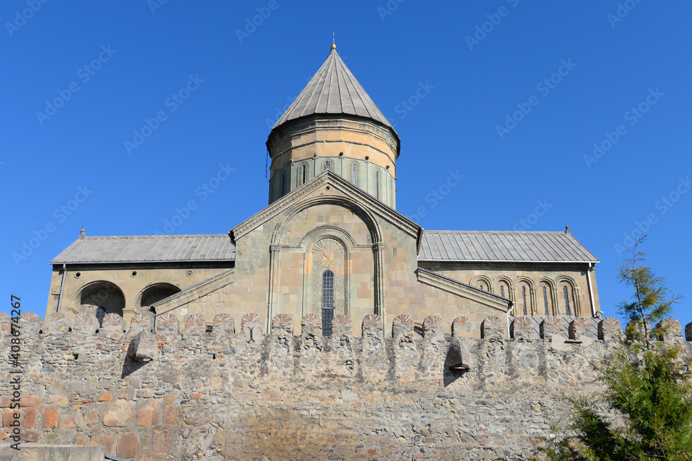 Lateral view of Svetitskhoveli Cathedral, located in Mtskheta, Georgia in the Caucasus. Orthodox Christian church with wall in front. World Heritage.