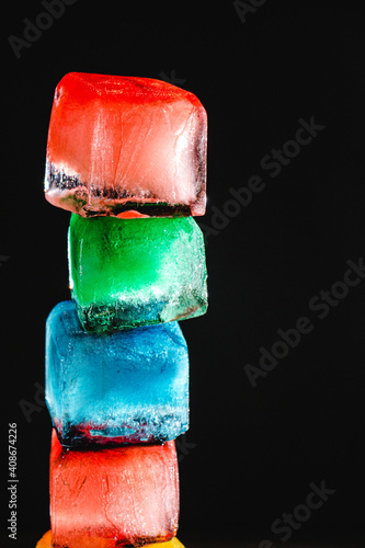 colored ice cubes stacked on black background