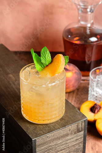 peach whiskey cocktail on wood table
