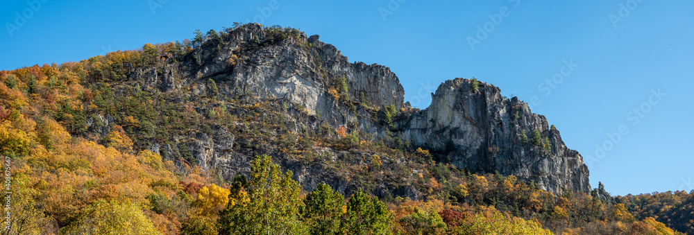 Panorama of Seneca Rocks in West Virginia, rocky cliffs rising out of an autumn forest. Panorama of Seneca Rocks in West Virginia, rocky cliffs rising out of an autumn forest.