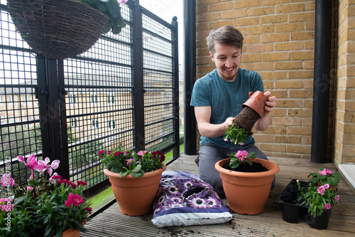 Young man enjoying doing some gardening on his balcony