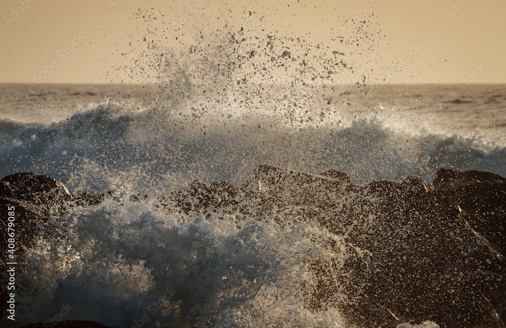 This idyllic image shows huge ocean waves crashing and splashing.